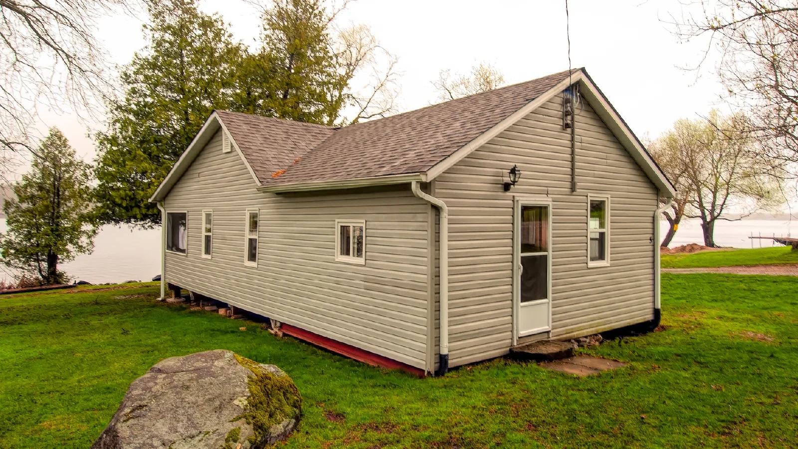 Pigeon Lake Resort Cottage three open-concept living and dining area with table, chairs, sofas, and window view.